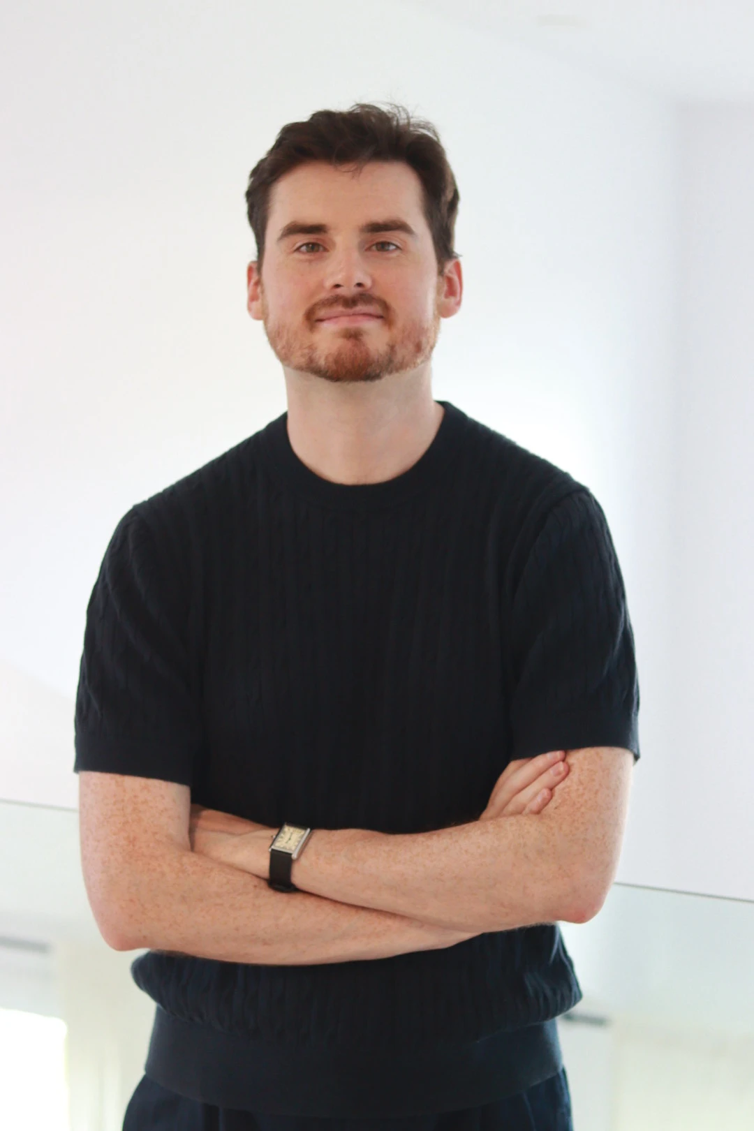 Jeremy McWilliams, founder of Chateau Mojo, arms crossed in a navy cable-knit top